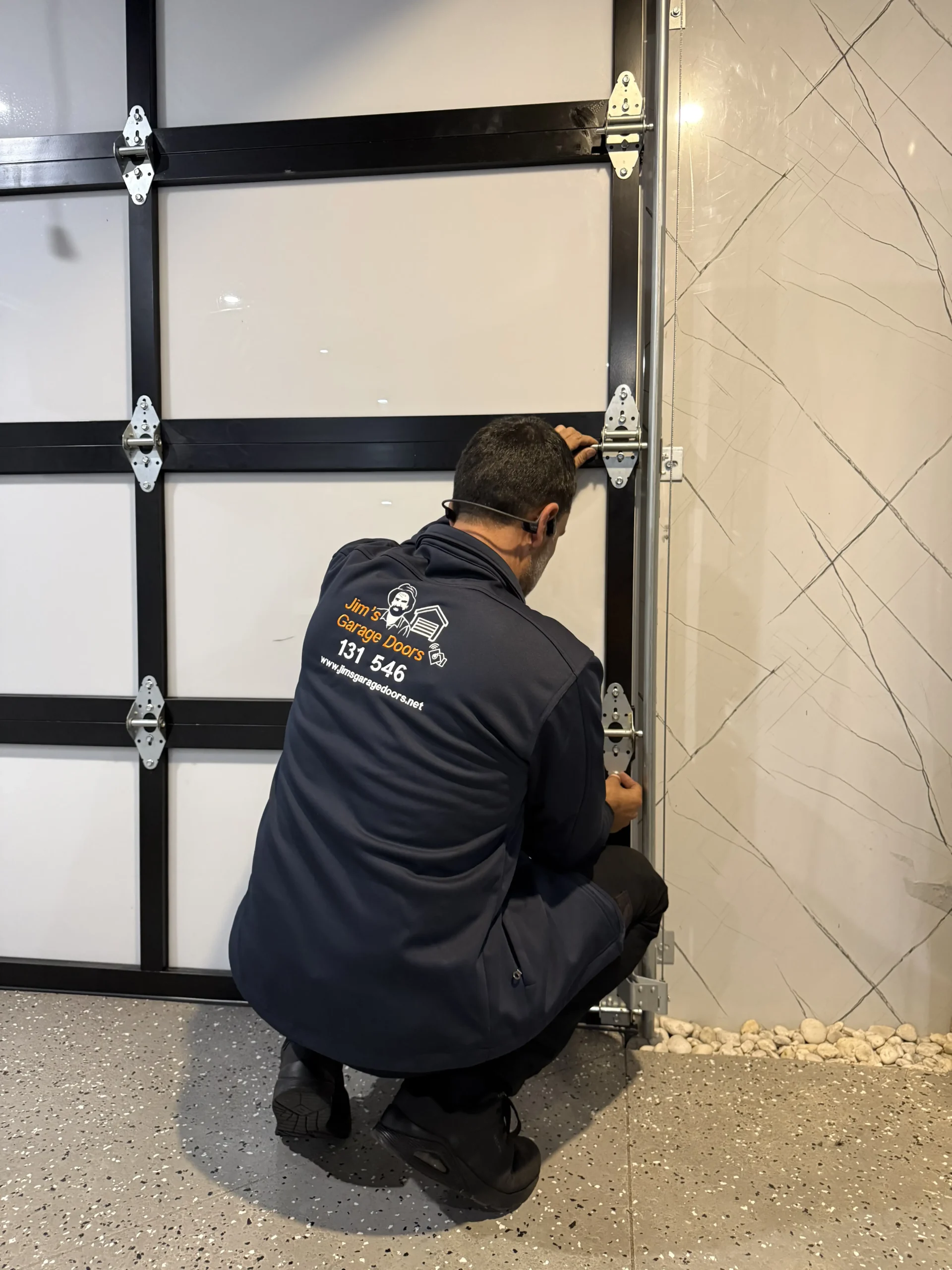 Garage door technician inspecting mechanical components before opener diagnosis