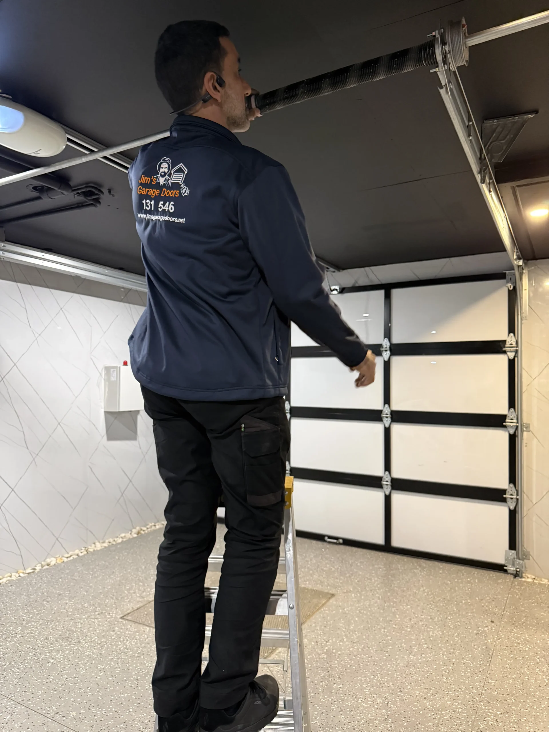 Garage door technician inspecting mechanical and automatic operating components