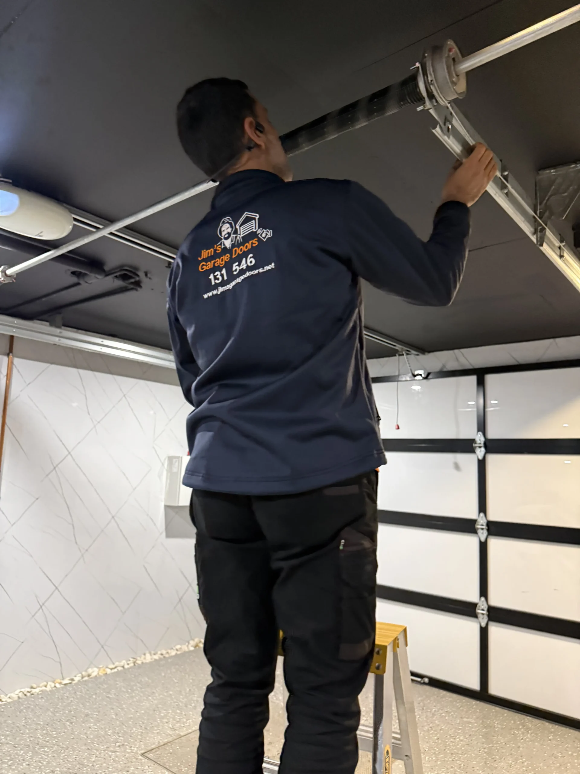 Garage Door Installation Site Assessment Garage door technician inspecting an opening before installation